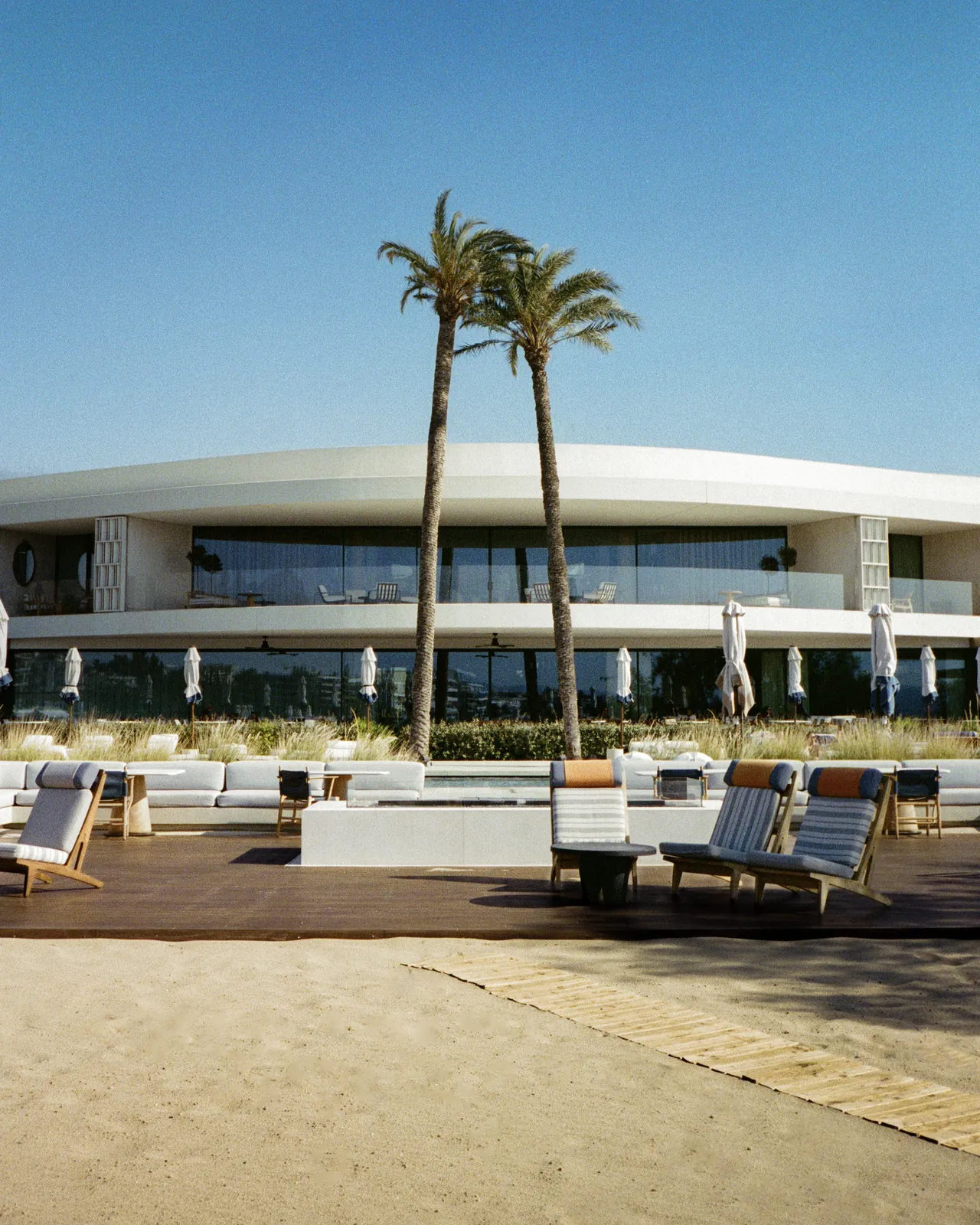 Two palms in front of a curved white beach club